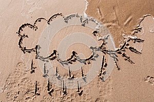 Sun and cloud drawing on beach sand