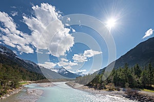Sun and clouds over flowing river