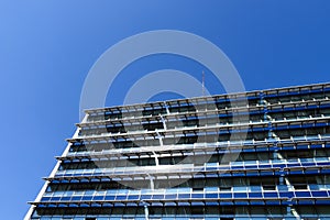 Sun collector solar panels installed on office building`s glass facade