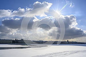 The sun comes out from behind the clouds over the frozen Neva River in St. Petersburg, opening up from the ice