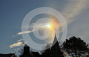 Sun dog and cirrus cloud above a church.