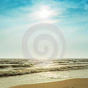 Sun in dramatic sky over sea