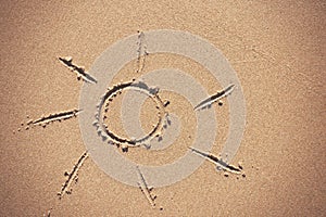 Sun drawing on beach sand.