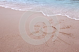 Sun drawn in the sand on the seashore
