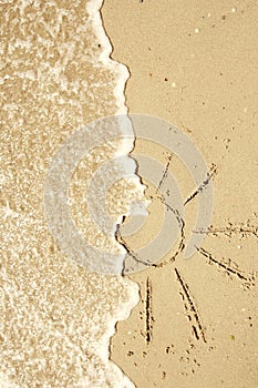 Sun drawn in the sand on the seashore