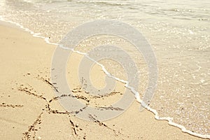 Sun drawn in the sand on the seashore