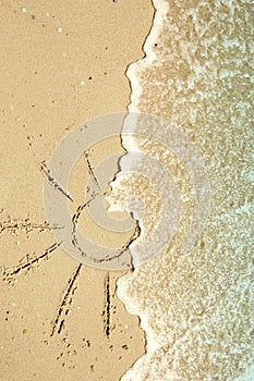 Sun drawn in the sand on the seashore