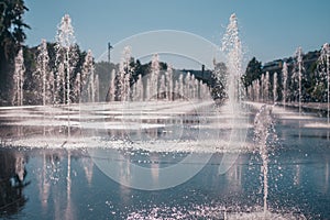 sun-drenched wet square from numerous fountains