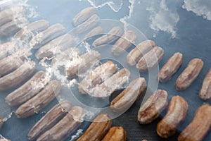 Sun-dried banana in solar dryers at sunny day. Abstract reflection of sunbeam with clouds on solarâ€™s glass. Sun-dried banana is