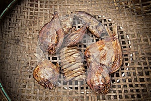 Sun-dried salted fish on bamboo threshing basket on a sunny day Closeup dried fish on the threshing basket. Salty dry Snakeskin go