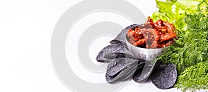 Sun-dried tomatoes and black chips. Chips and Tomatoes copy space