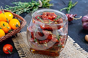 Sun-dried tomatoes with herbs, garlic in olive oil in a glass jar