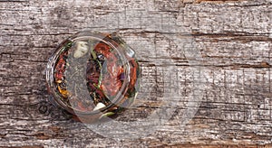 Sun dried tomatoes with herbs and olive oil in jar