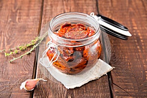 Sun dried tomatoes with herbs and sea salt in olive oil in a gla