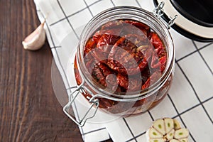 Sun dried tomatoes with herbs and sea salt in olive oil in a gla