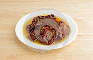 Sun dried tomatoes with olive oil on white plate