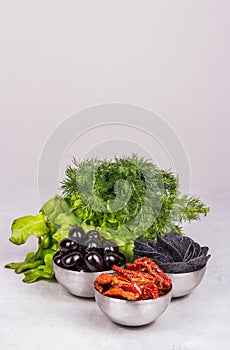 Set of delicious snacks. Sun-dried tomatoes and olives with fresh herbs