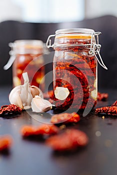 Sun-dried tomatoes are packed in a jar with spices and garlic and drenched in olive oil.