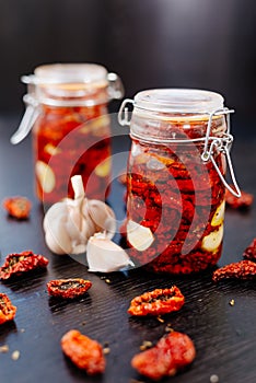 Sun-dried tomatoes are packed in a jar with spices and garlic and drenched in olive oil.