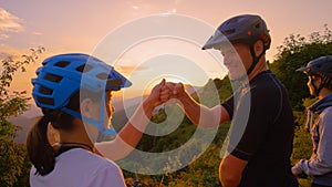 SUN FLARE: Cheerful tourists fist bump at sunset after a successful bike trip.