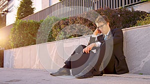 SUN FLARE Young Caucasian man sitting on the street and mourns after being fired photo