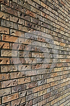 Sun glances off a brick wall with impressions giving it texture background