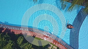 Sun glare on pool water near swimming girl