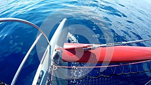 Sun glare reflected in blue sea water overboard of a moving boat