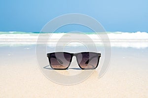 Sun glasses lie on a beach near the sea