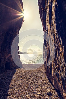 Sun glinting through a cave at Bussaglia beach in Corsica