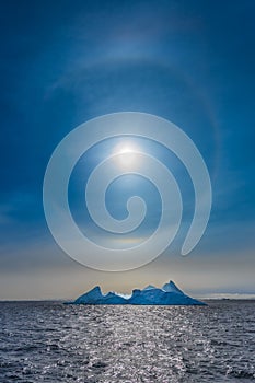 Sun Halo shining over the blue iceberg and ocean, North Greenland