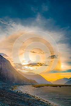Sun halo during sunset in Ladakh with high mountains and river, India