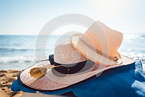 Sun hats and glasses on beach by the water