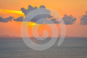 Sun hides behind clowds dramatic and colorful sunset at beach photo