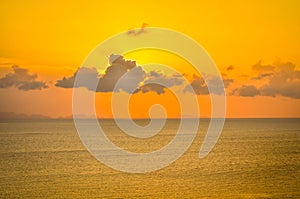 Sun hides behind clowds dramatic and colorful sunset at beach photo