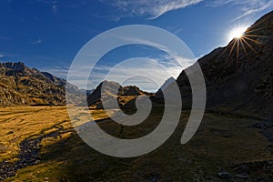 The sun hides behind mountain