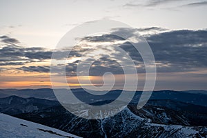 Slunce se schovává za mraky při východu slunce v zimních horách, slovensko nízké Tatry, dumbier