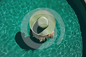 Sun-Kissed Poolside: Aerial View of Woman Enjoying Summer in Hat