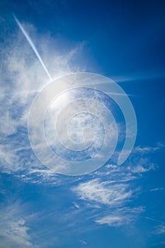 Sun with lens flare, on blue sky background.