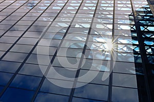 Sun light through blue glass corporate business building architecture background - with copyspace