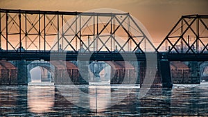 Sunrise through the arches of a series of bridges over the Susquehanna River in Harrisburg, PA photo