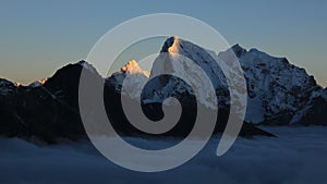 Sun lit peaks of Ama Dablam and Cholatse at sunset photo