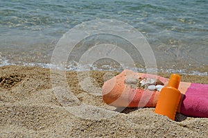 Sun lotion and towel on a beach
