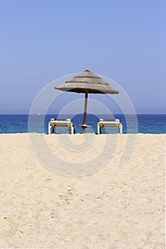 Sun lounger on empty sandy beach