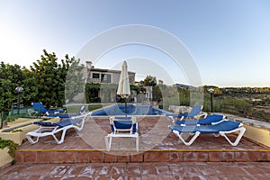 Sun lounger in front of a swimming pool and an finca