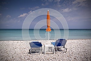 Sun lounger and umbrella on empty beach