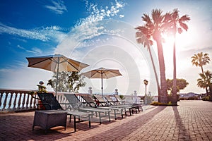 Sun loungers beach umbrellas and pool in sunset light