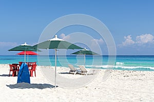 Sun loungers, chairs, table and umbrella on a tropical beach