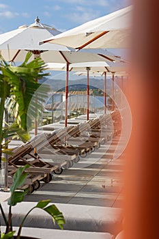 Sun loungers near pool with umbrella parasol beautiful sunny day