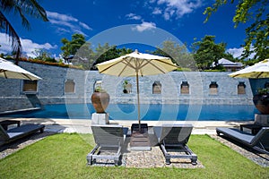 Sun loungers by poolside of resort hotel